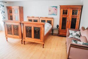 1 dormitorio con muebles de madera, 1 cama y 1 sofá en Apartmán v přírodě v srdci Vysočiny 1 en Jihlava