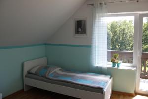 Dormitorio infantil con paredes azules y ventana en Ferienwohnug Zur alten Eiche en Bad Endbach