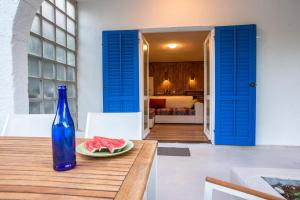 eine blaue Flasche auf einem Tisch mit einem Teller Wassermelone in der Unterkunft Casa Porozina - Paradise Beach in Cres