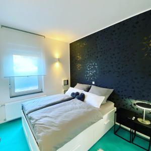 ライネにあるFerienwohnung K1889 Rheine - Elinの黒い壁のベッドルーム1室(大型ベッド1台付)
