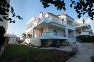 a large white building with balconies at Marias BBQ Garden House in Kalamata
