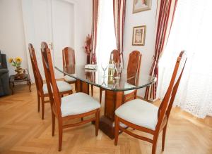een eetkamer met een glazen tafel en stoelen bij Apartments Opera in Wenen