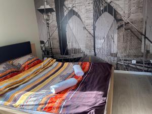 a bed in a room with a wall with a bridge at Cosy and peaceful apartment in Kaunas