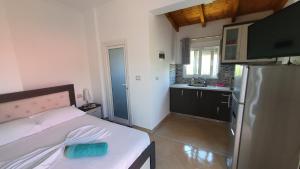 a bedroom with a bed and a kitchen with a refrigerator at Villa Denis Ksamil in Ksamil