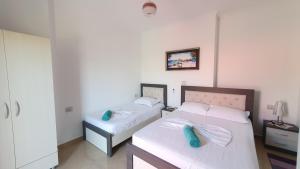 a bedroom with two beds with blue pillows on them at Villa Denis Ksamil in Ksamil