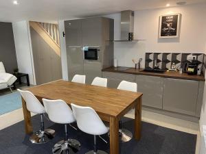 a kitchen with a wooden table and white chairs at Appartement 3km Disneyland Paris 4 à 6 personnes in Magny-le-Hongre