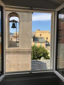 uma vista de uma janela com um sino em Appartement Place du Marché Bastia em Bastia