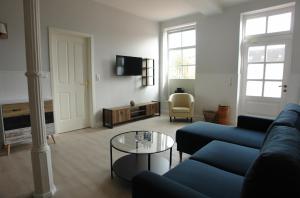 ein Wohnzimmer mit einem blauen Sofa und einem Tisch in der Unterkunft Friesischer Hof (Luftkurort) in Hage