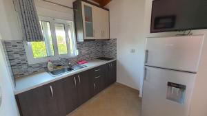 a kitchen with a white refrigerator and a sink at Villa Denis Ksamil in Ksamil