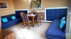 a dining room with a table and a blue couch at Royal Blue przy samym Morzu Plaży in Primorsko