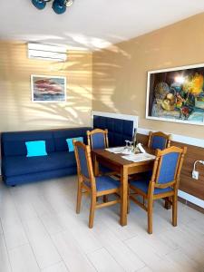 a dining room with a blue couch and a table and chairs at Royal Blue przy samym Morzu Plaży in Primorsko