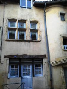 ein Gebäude mit einer blauen Tür und mehreren Fenstern in der Unterkunft Le Colimaçon in Cluny