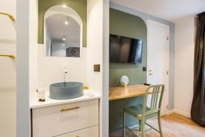 a bathroom with a sink and a desk with a chair at CMG BHV Marais / Rue Vieille du Temple in Paris