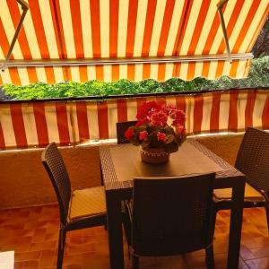 een tafel en stoelen met een vaas met bloemen erop bij vacances à la plage in Saint-Cyr-sur-Mer