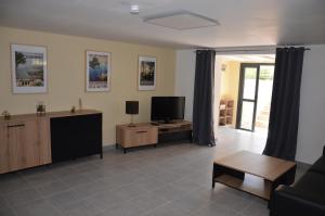 ein Wohnzimmer mit einem TV und einem Sofa in der Unterkunft Vue Sainte Victoire, proche Aix-en-Provence in Pourrières