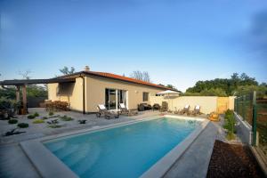 a swimming pool in front of a house at Pola kuće sa bazenom-Eja in Kaštel