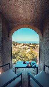 a table and chairs on a porch with a view of the ocean at Charm Nature in Azoia