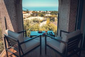 a table and chairs on a balcony with a view of the ocean at Charm Nature in Azoia