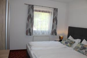 a bedroom with a white bed and a window at Appartement Steinbichler in Graz