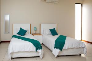 マプトにあるTriunfo Guest Houseのベッドルーム1室(隣り合わせのベッド2台付)