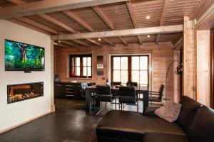 a living room with a fireplace and a dining room at Houten Villa Dirk in Den Ham