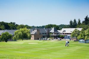 two people are standing on a golf course at Saint Malo Golf Resort in Le Tronchet