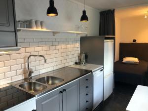 a small kitchen with a sink and a refrigerator at Mormors vrå in Mora