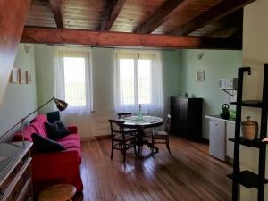 een woonkamer met een rode bank en een tafel bij Country House Cascina Orto in Pasturana