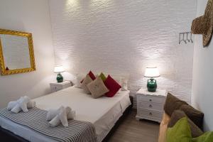una camera con 2 letti, 2 lampade e uno specchio di Il Giardino di Sybar a Lecce