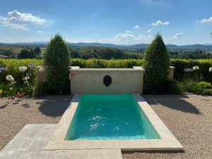 une piscine au milieu d'un jardin dans l'établissement Le Mazet d'Emilia avec jardin et piscine privés, à Cucuron