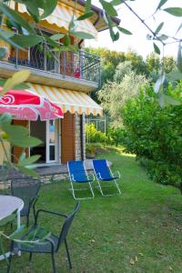 due sedie e un ombrellone nel cortile di una casa di Casa Antonia a Brenzone sul Garda
