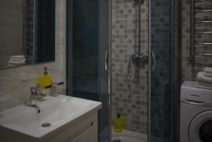 een badkamer met een douche, een wastafel en een toilet bij Modern apartmeents near Central Park in Poltava