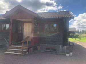 a log cabin with a porch and a door at Mormors vrå in Mora