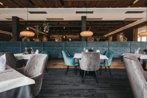 a restaurant with white tables and blue chairs at Hotel Wagnerhof in Pertisau