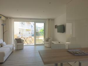 ein Wohnzimmer mit einem Sofa und einem Tisch in der Unterkunft STUDIO LES ALGUES in Cannes