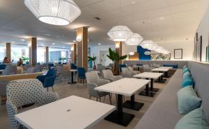 a dining room with tables and chairs and lights at Medplaya Hotel Regente in Benidorm