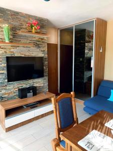 a living room with a television on a brick wall at Royal Blue przy samym Morzu Plaży in Primorsko