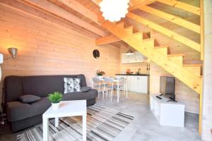 a living room with a couch and a kitchen at Domki Apartamenty Akacja in Sianozety