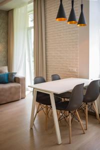 a dining room with a white table and chairs at Modern apartmeents near Central Park in Poltava