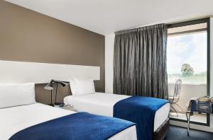 a hotel room with two beds and a window at Punthill Oakleigh in Oakleigh