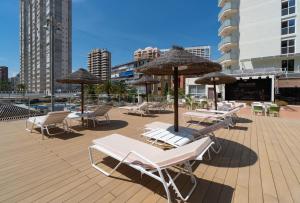 un gruppo di sedie e ombrelloni su una terrazza di Medplaya Hotel Regente a Benidorm