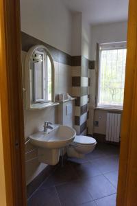 bagno con lavandino, servizi igienici e finestra di Casa Antonia a Brenzone sul Garda