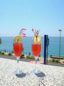 dos copas de vino sentadas en una mesa cerca del océano en Sea Garden Hotel, en Acquappesa