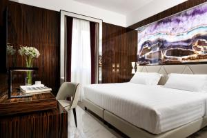 a bedroom with a large bed and a desk with a bed sidx sidx at Le Boutique Hotel in Rome