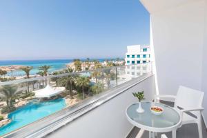 a balcony with a table and a view of the ocean at Tasia Maris Beach Hotel - Adults Only in Ayia Napa