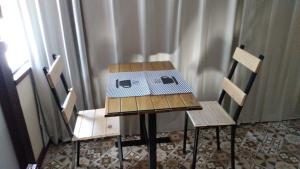 d'une table et de deux chaises avec une boîte. dans l'établissement Loft Santos Dumont, à Nova Friburgo