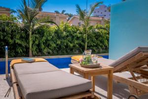 a bed and a table next to a pool at Tasia Maris Beach Hotel - Adults Only in Ayia Napa