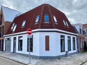 un edificio rojo y blanco con techo rojo en Het Hoekje - 2 bedroom family friendly city home, en Groninga