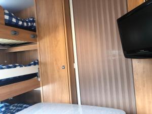 a room with a tv and a bed and a closet at Zillerglückhütte - 5 Sterne Camping Aufenfeld in Aschau