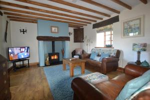 a living room with a couch and a fireplace at Siabod Luxury Cottage in Betws-y-coed